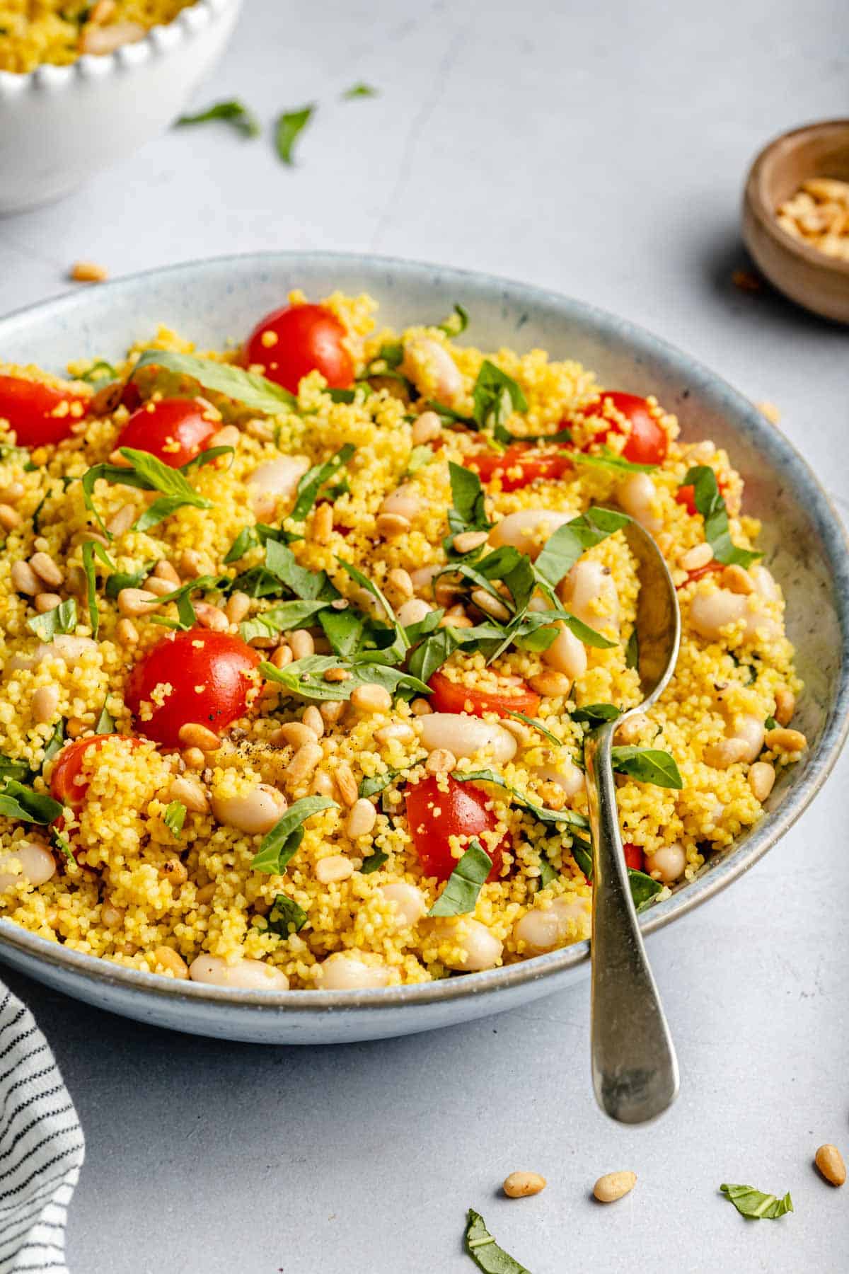 Couscous salad served in a bowl and garnished with fresh basil.
