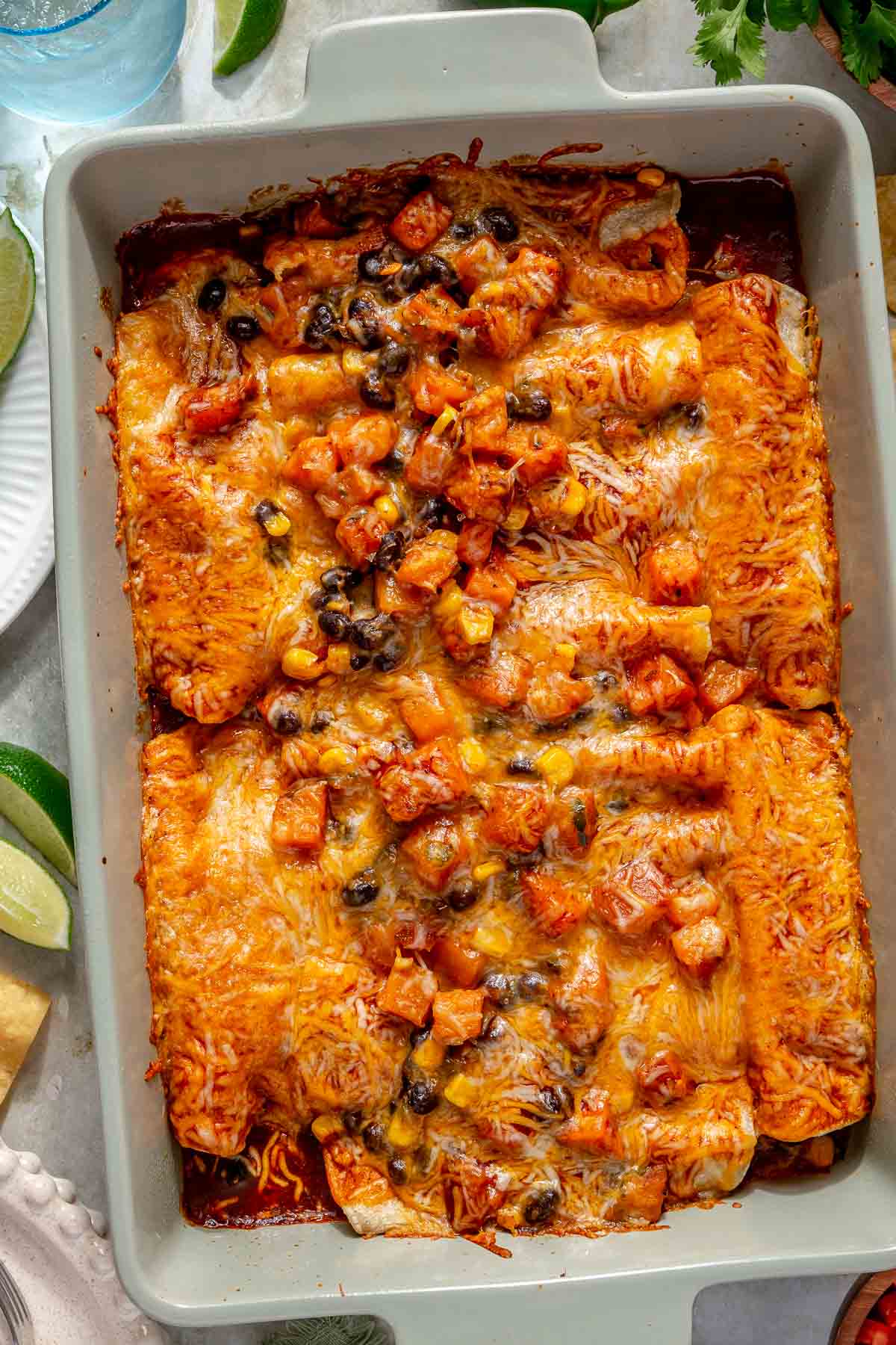 Baked sweet potato black bean enchiladas in a pan.