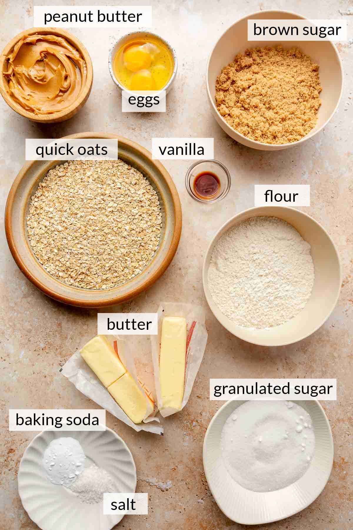 Quick oats, flour, sugar, eggs, peanut butter and salt divided into small bowls.