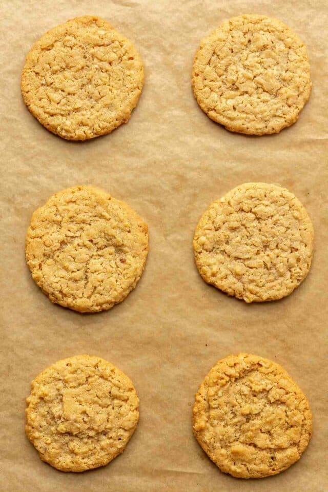 Baked peanut butter oatmeal cookies on a baking sheet pan lined with parchment paper.