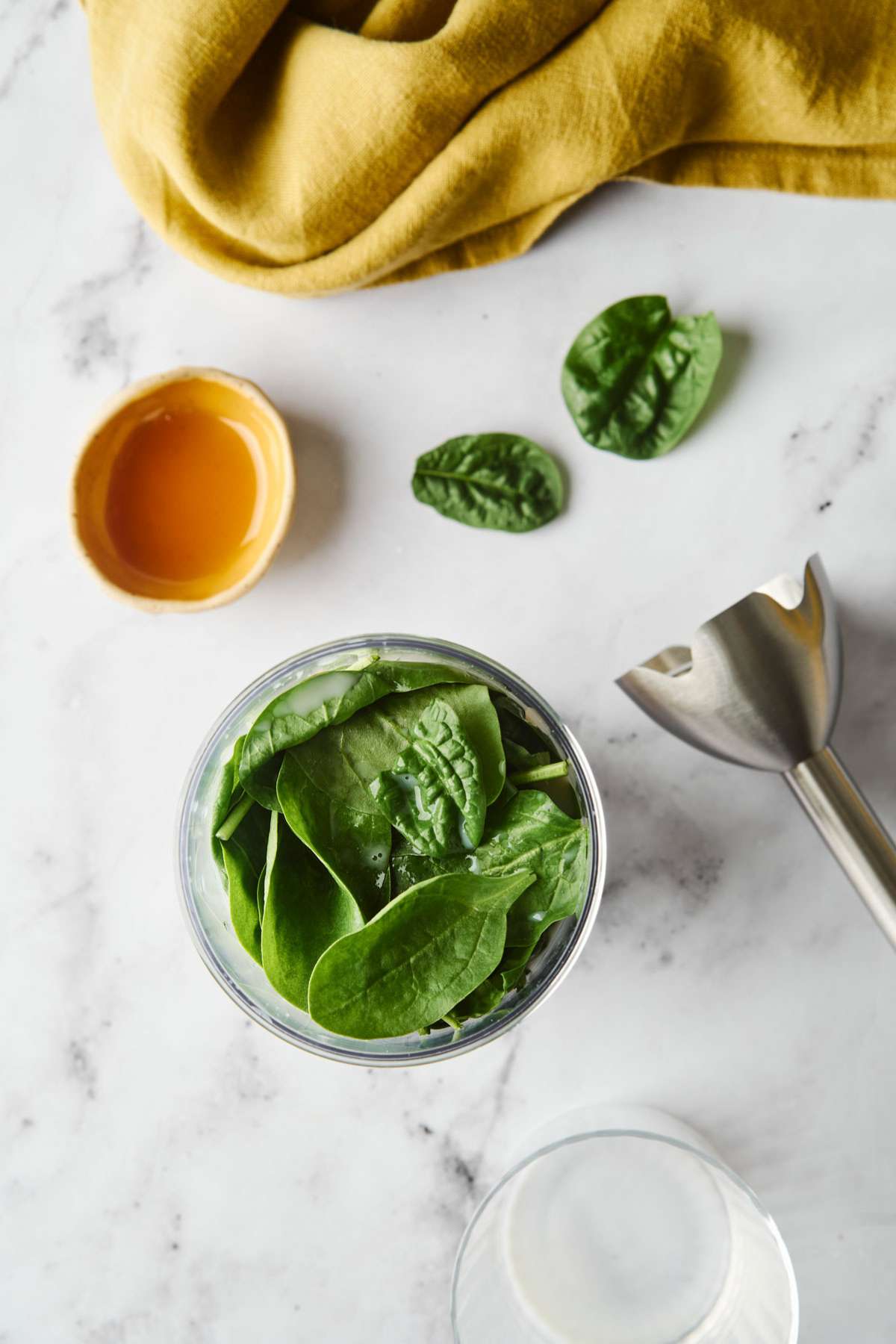 Spinach leaves added to a blender.