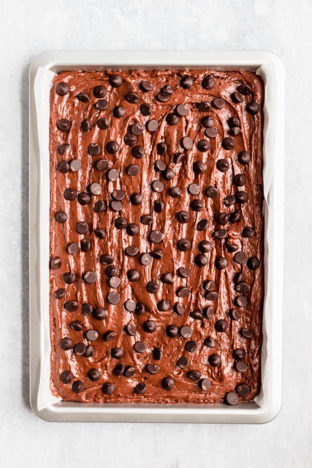 chocolate brownie batter spread out in a 9x13" glass baking dish