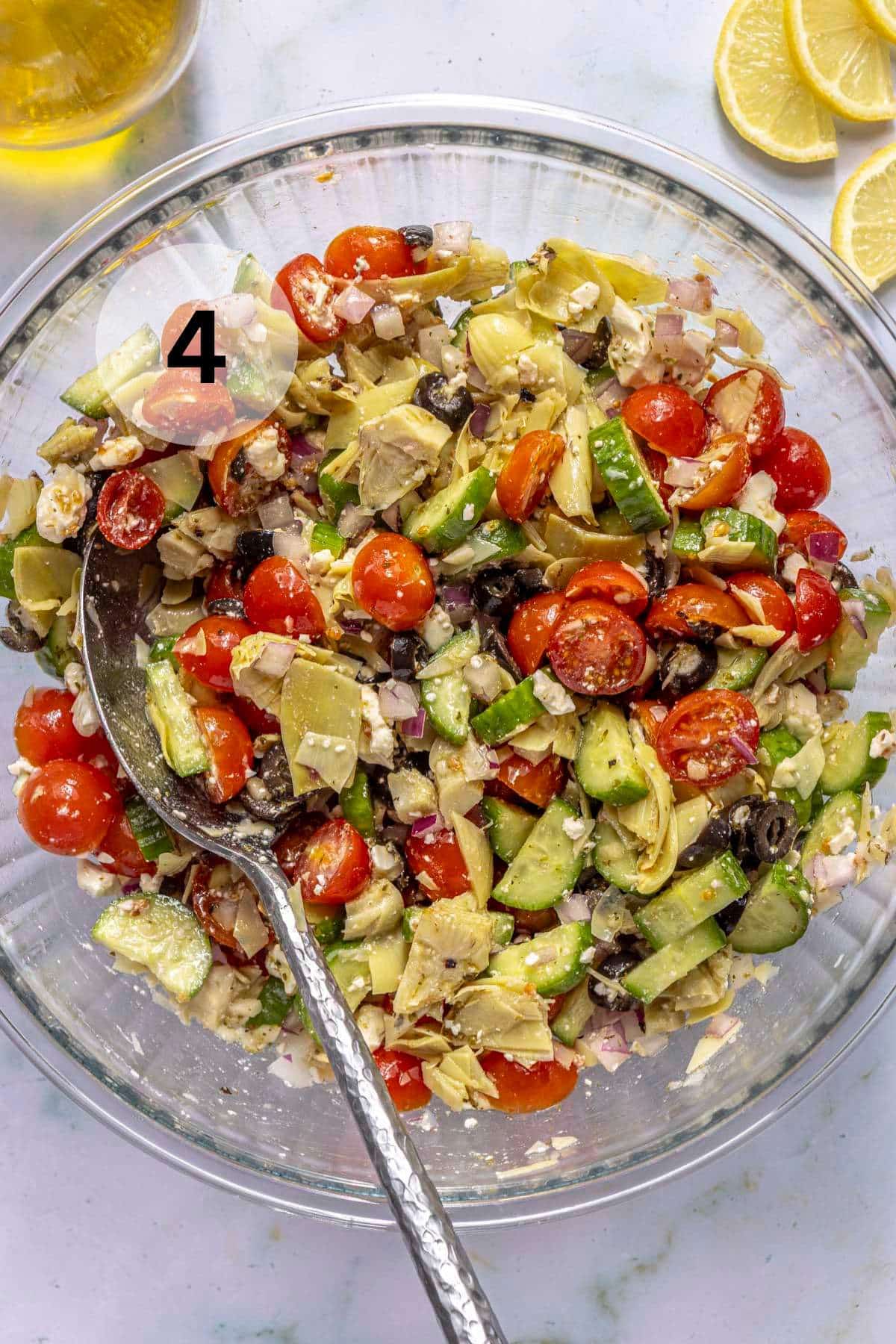 Tossing a Greek Salad with a large serving spoon.