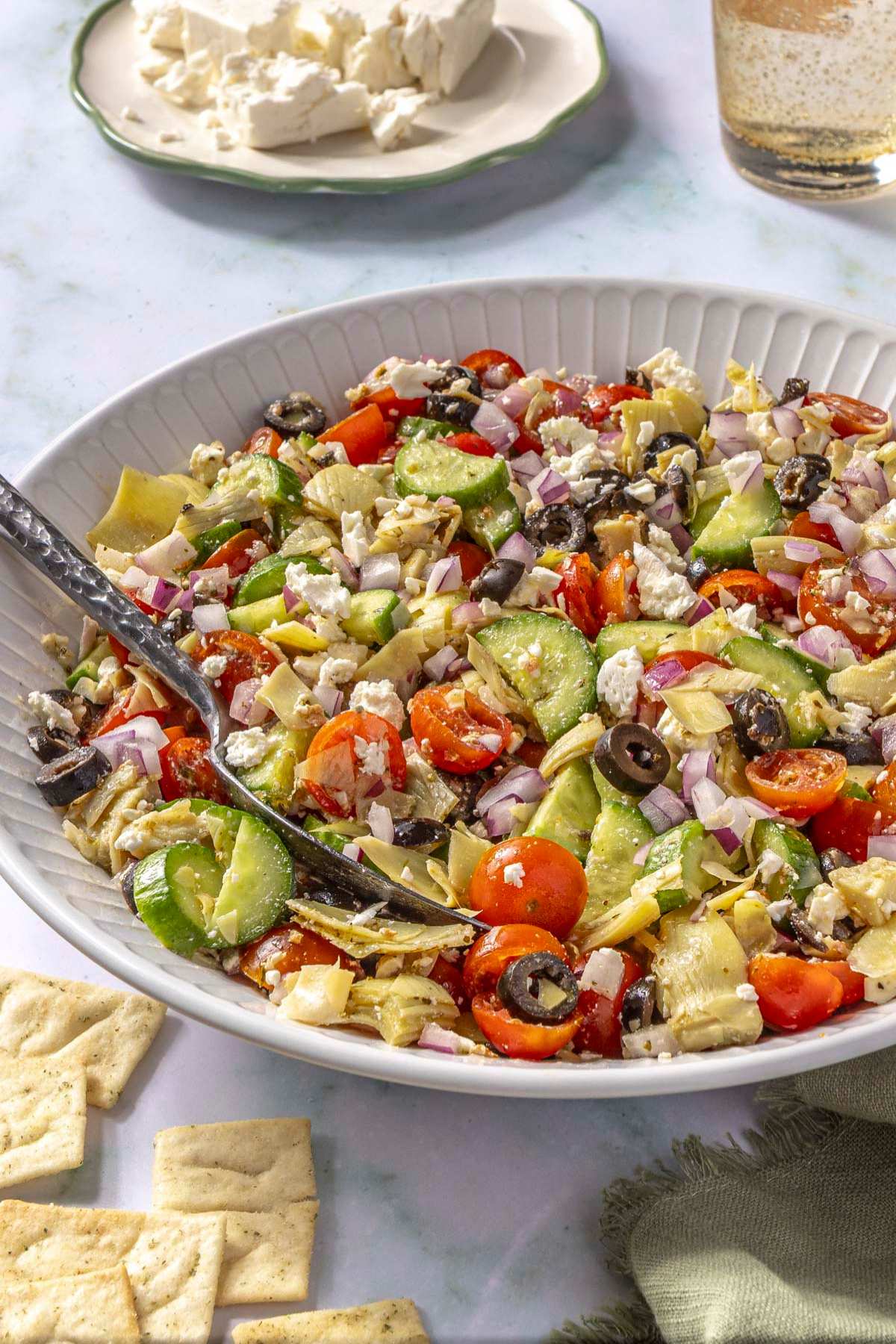 Greek Salad served with pita chips near crumbled feta.