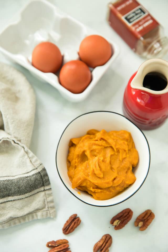 overhead view of ingredients (eggs, pumpkin purée and pumpkin pie spice) to make Flourless Pumpkin Pancakes