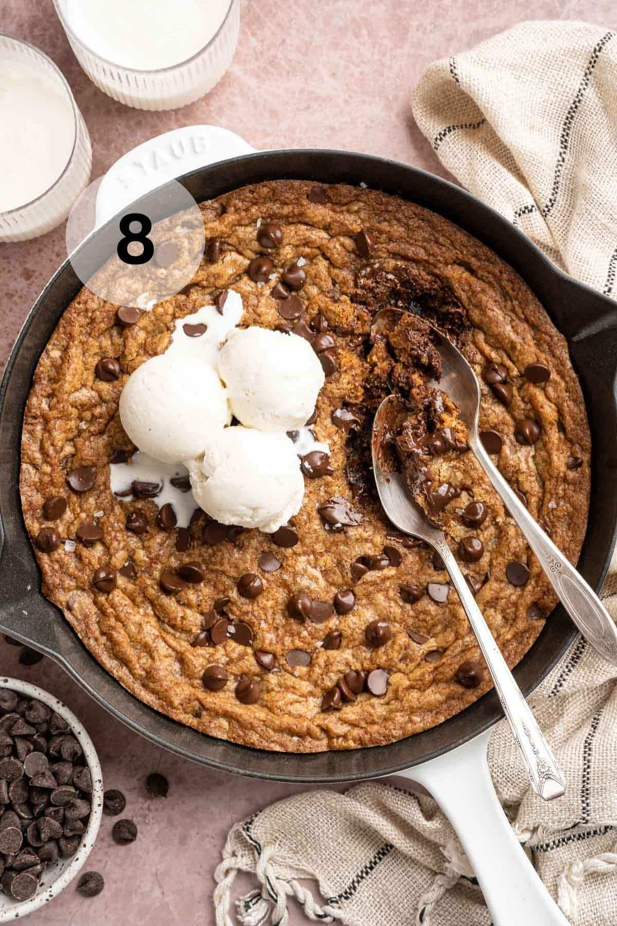 Cookie skillet topped with vanilla ice cream and served with spoons.