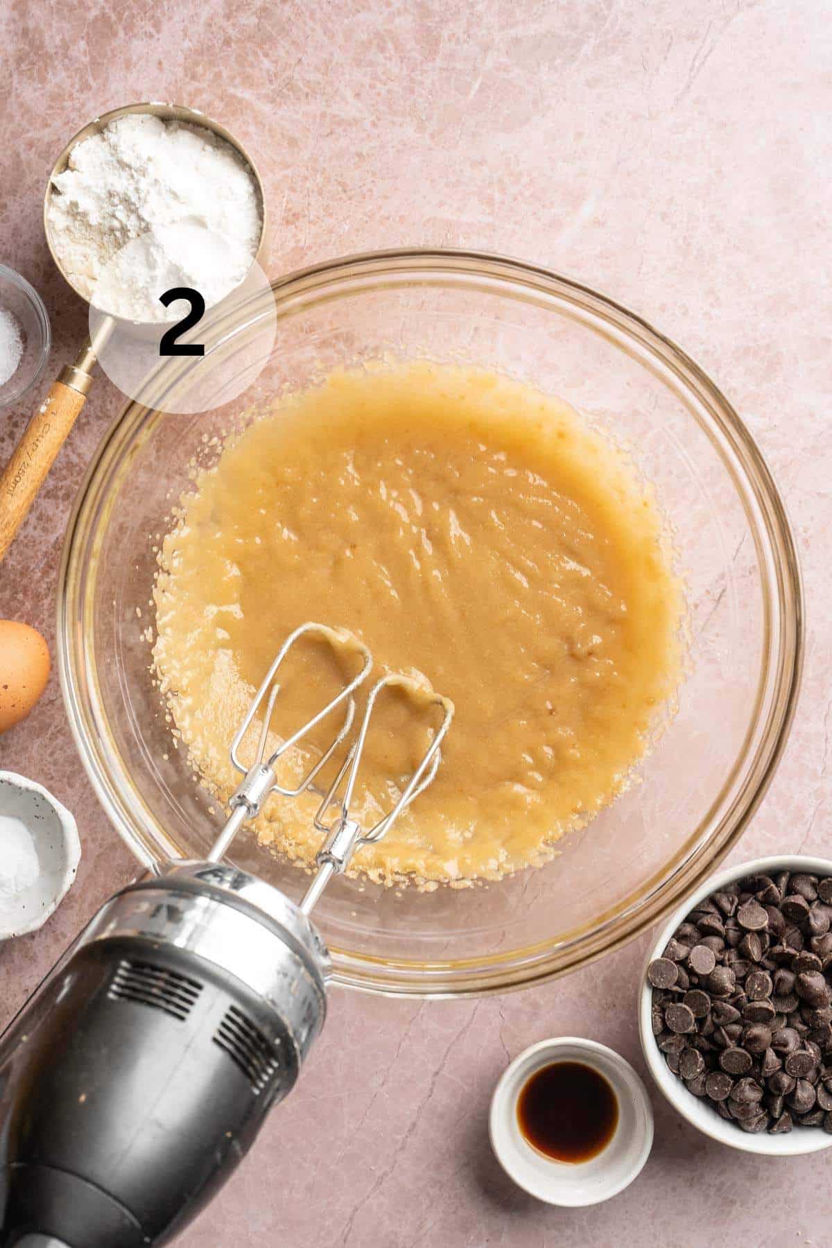Beating butter with sugars in a mixing bowl.