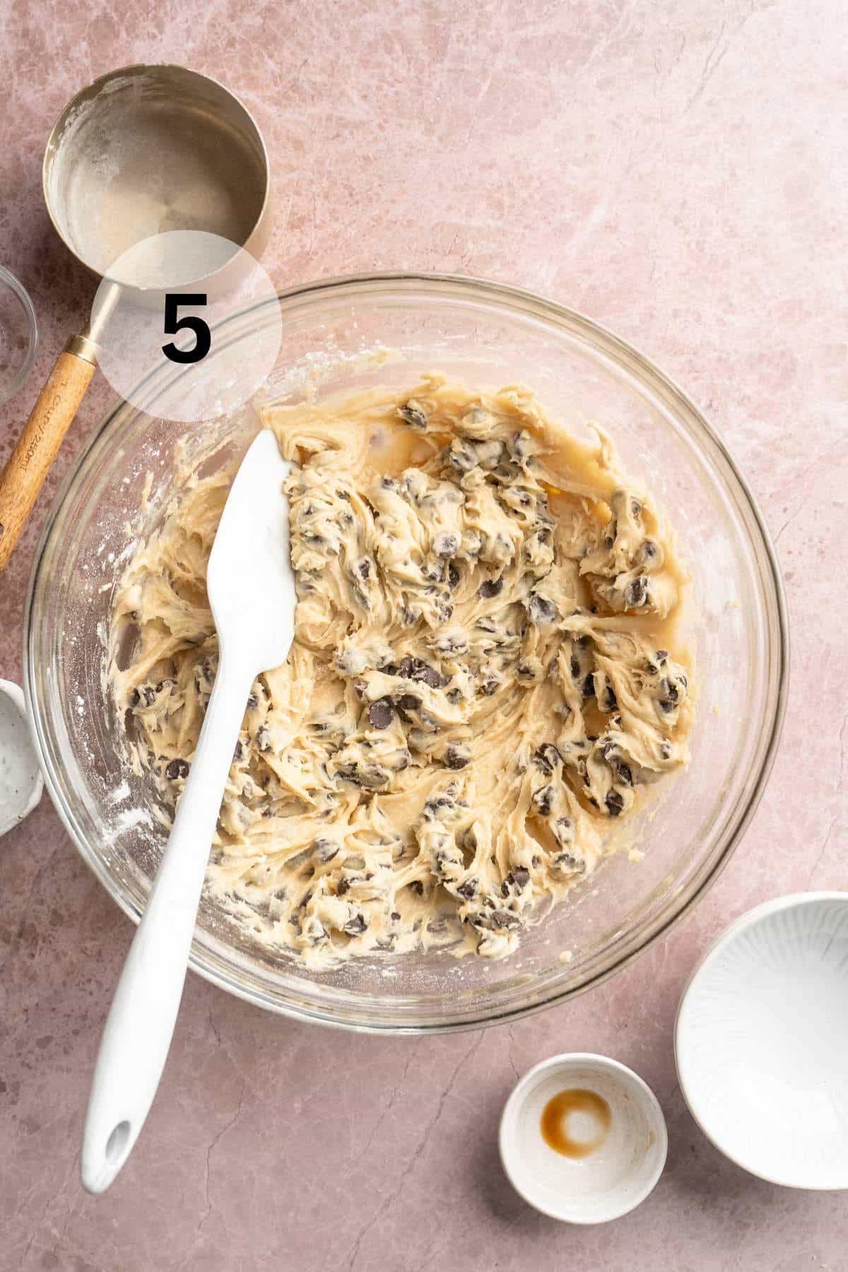 Folding chocolate chips into cookie dough.