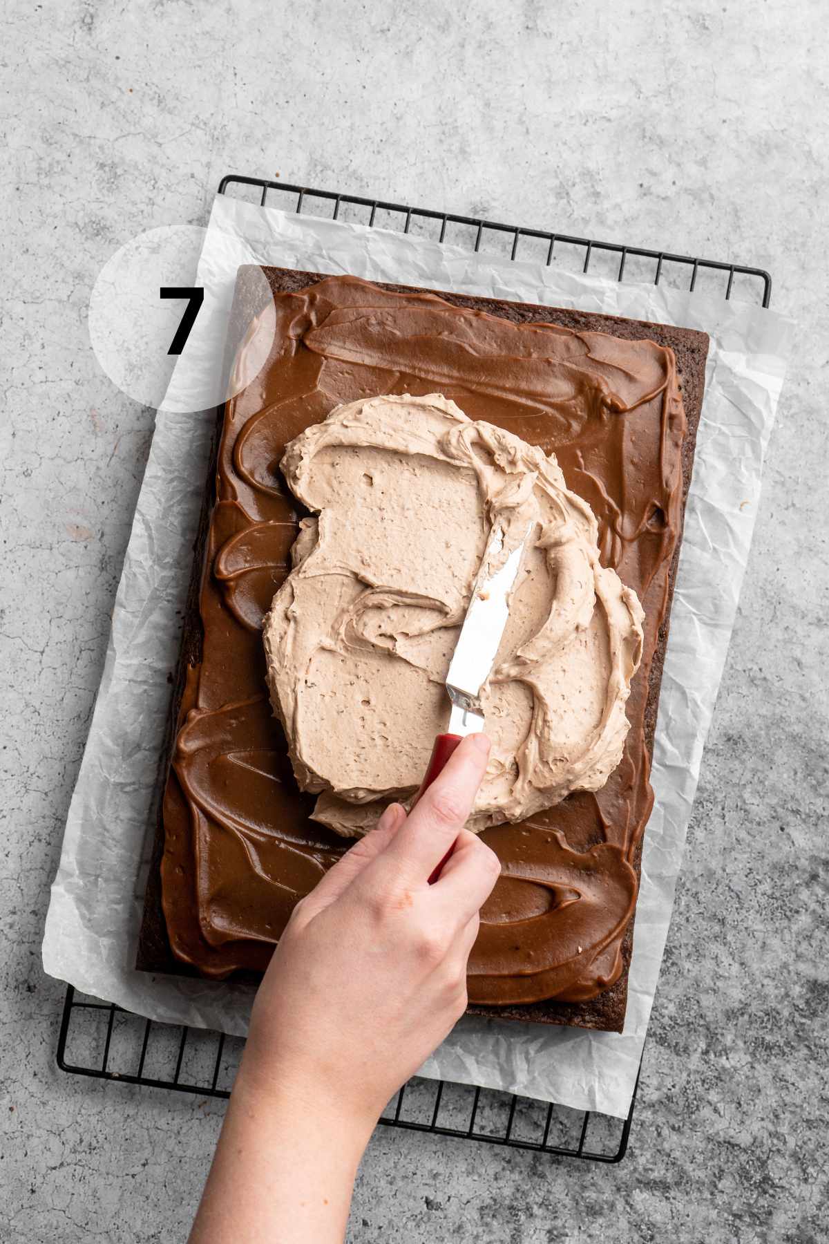 Spreading frosting over a chocolate cake.