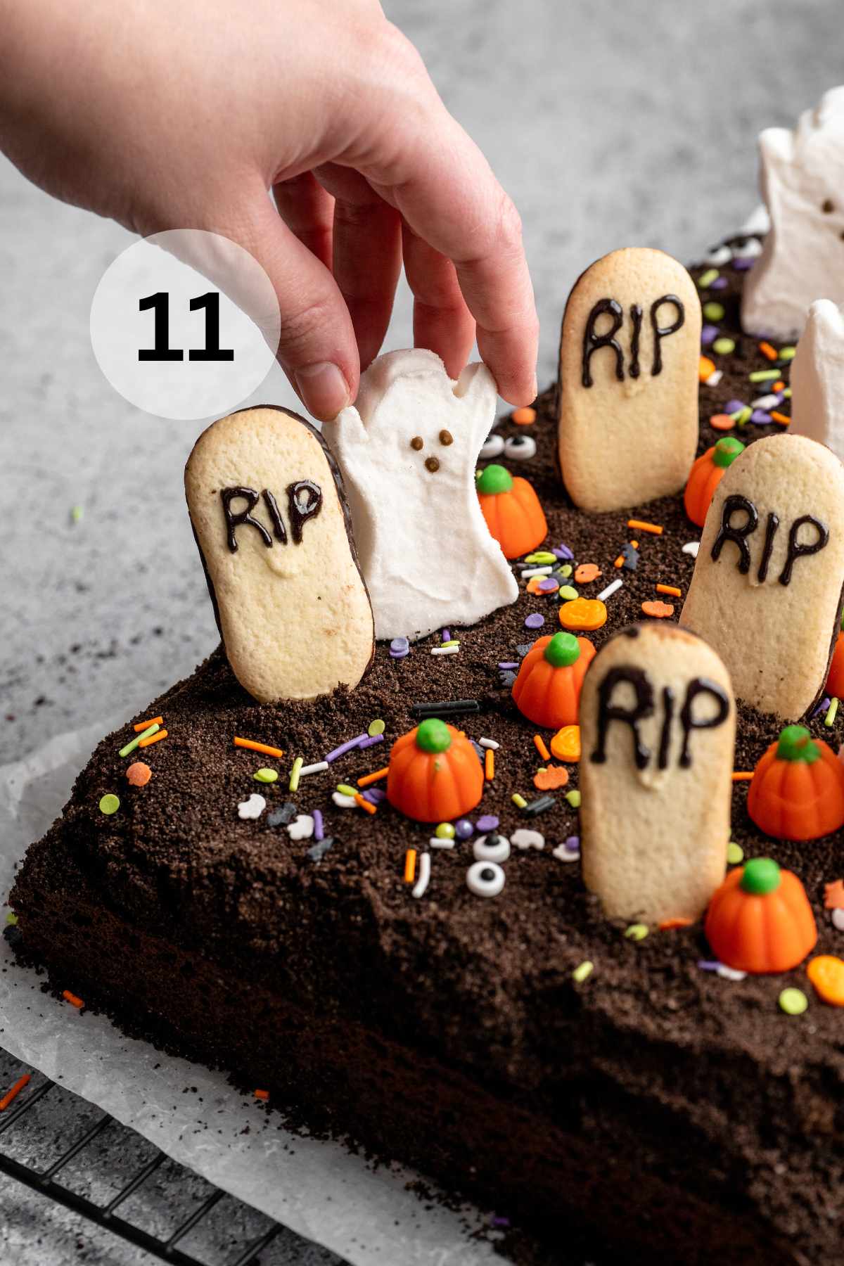Adding ghost peeps to a graveyard cake.
