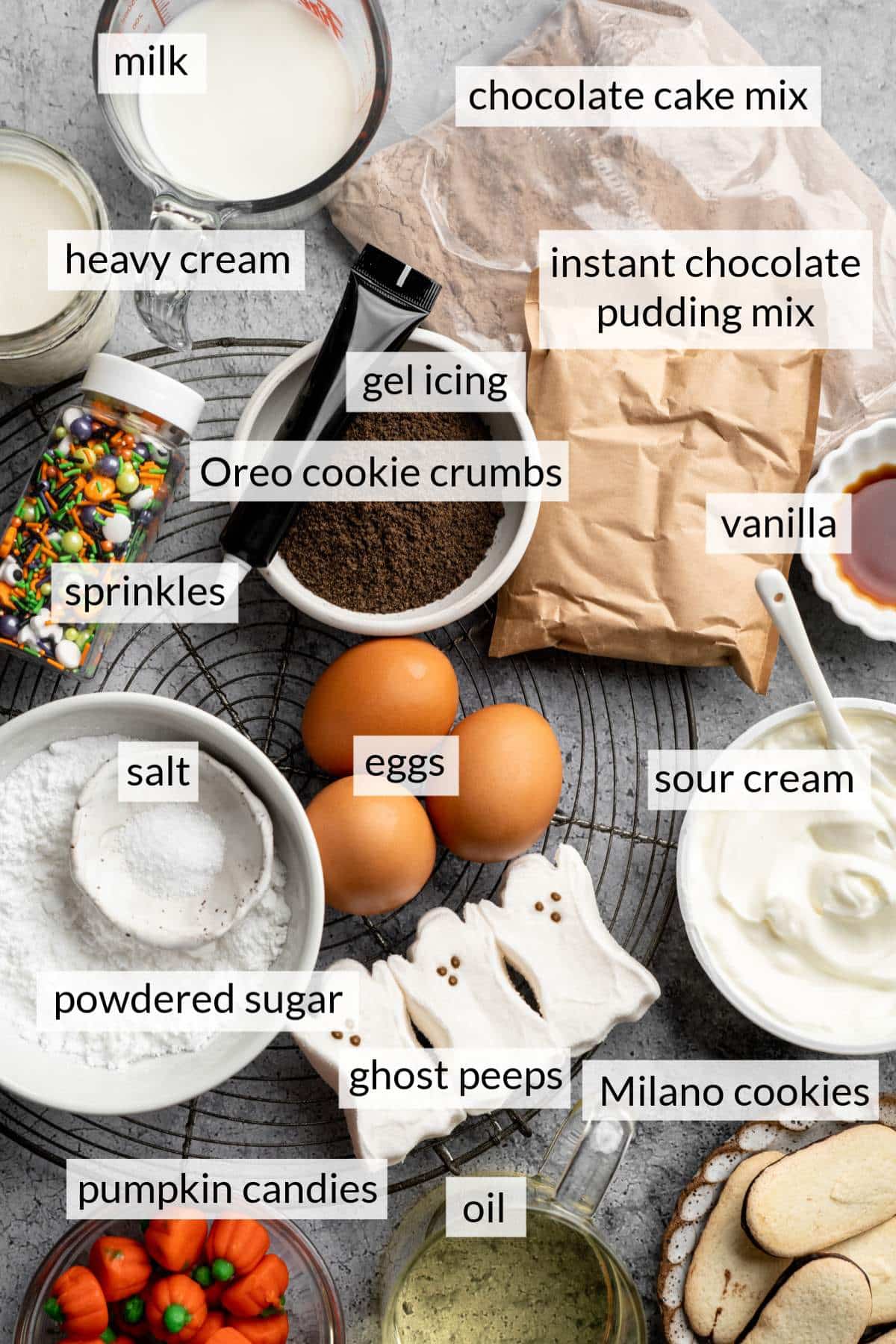 Small bowls of milk, powdered sugar and sour cream near eggs, ghost peeps and pumpkin candies.
