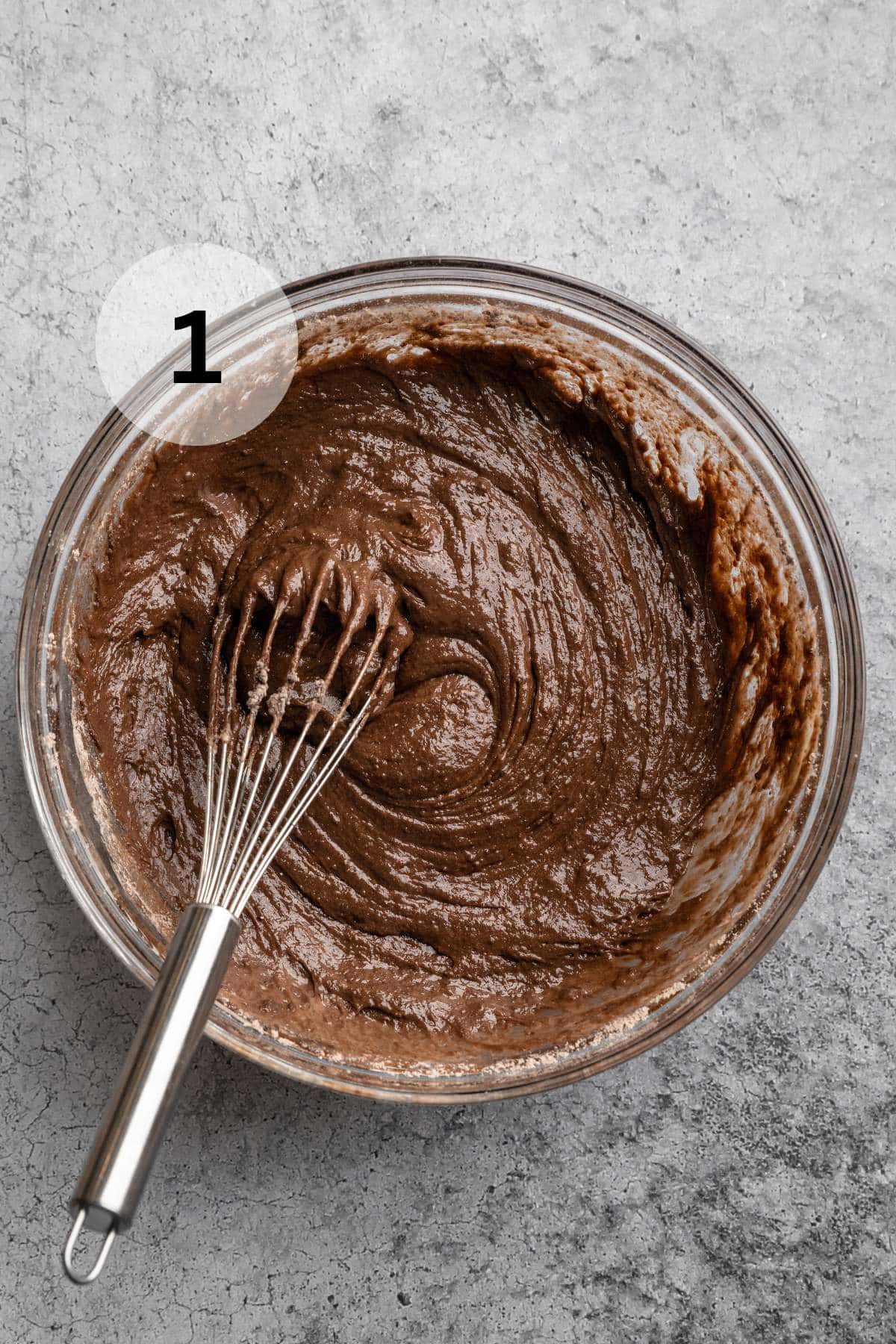 Mixing chocolate cake batter with a whisk.