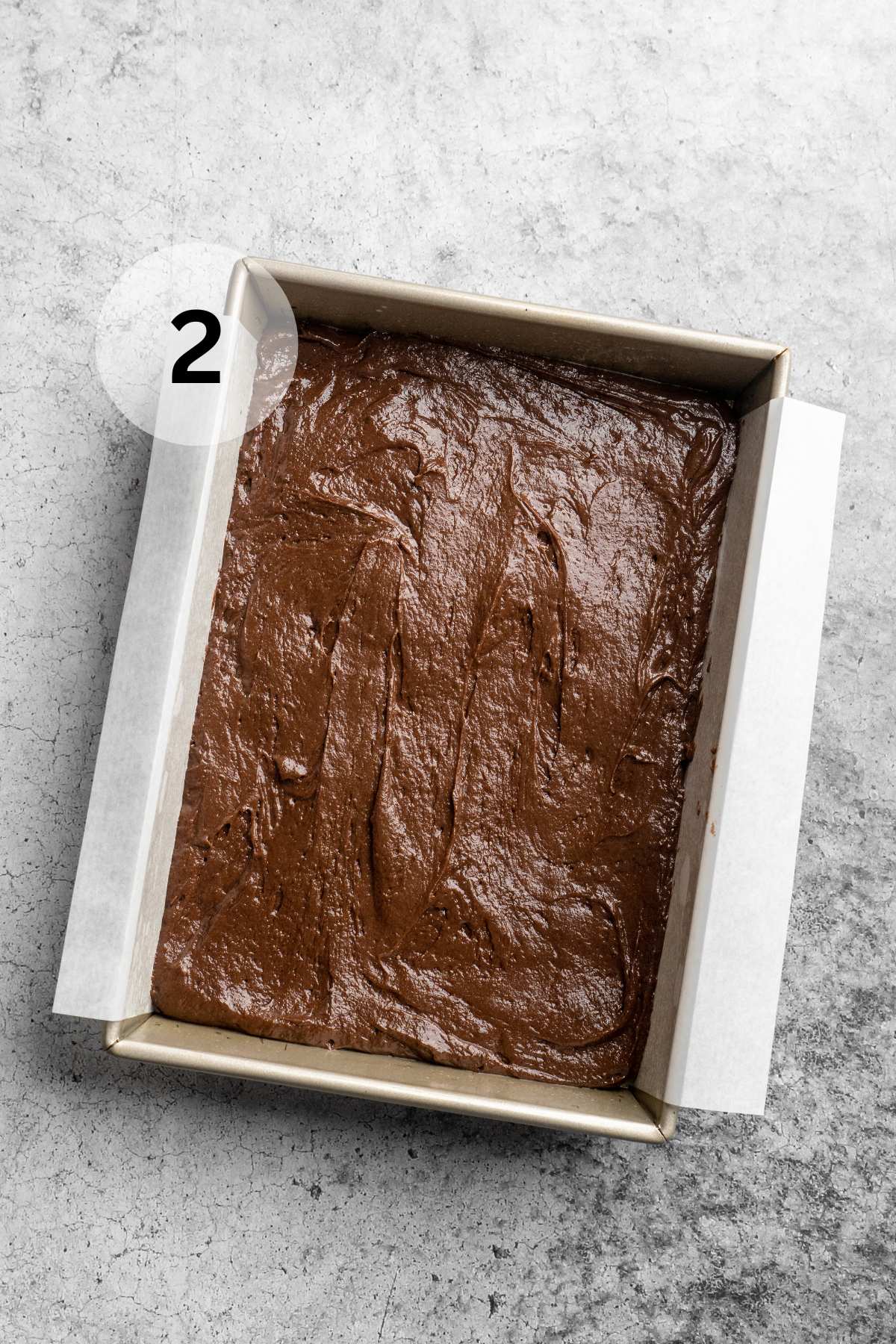 Cake batter spread in a prepared baking pan.