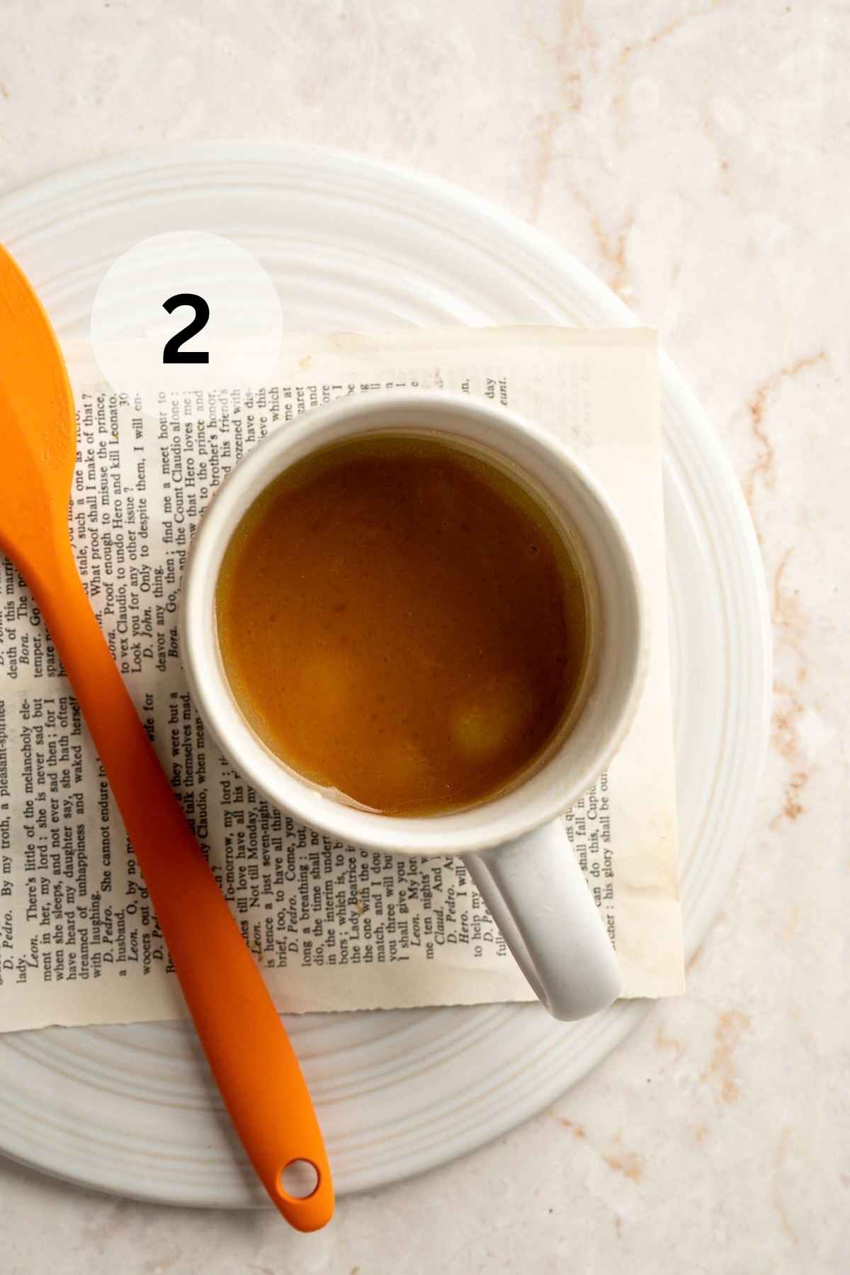 A mixture of butter, milk, pumpkin, brown sugar, vanilla and salt in a white mug.