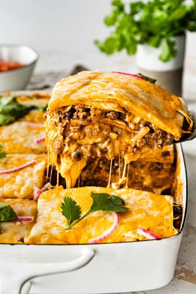 serving mexican lasagna out of a casserole dish