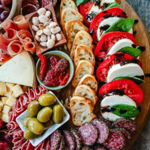 Italian charcuterie board with mozzarella and tomatoes.