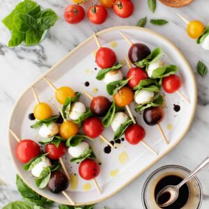 Caprese skewers on a white plate.