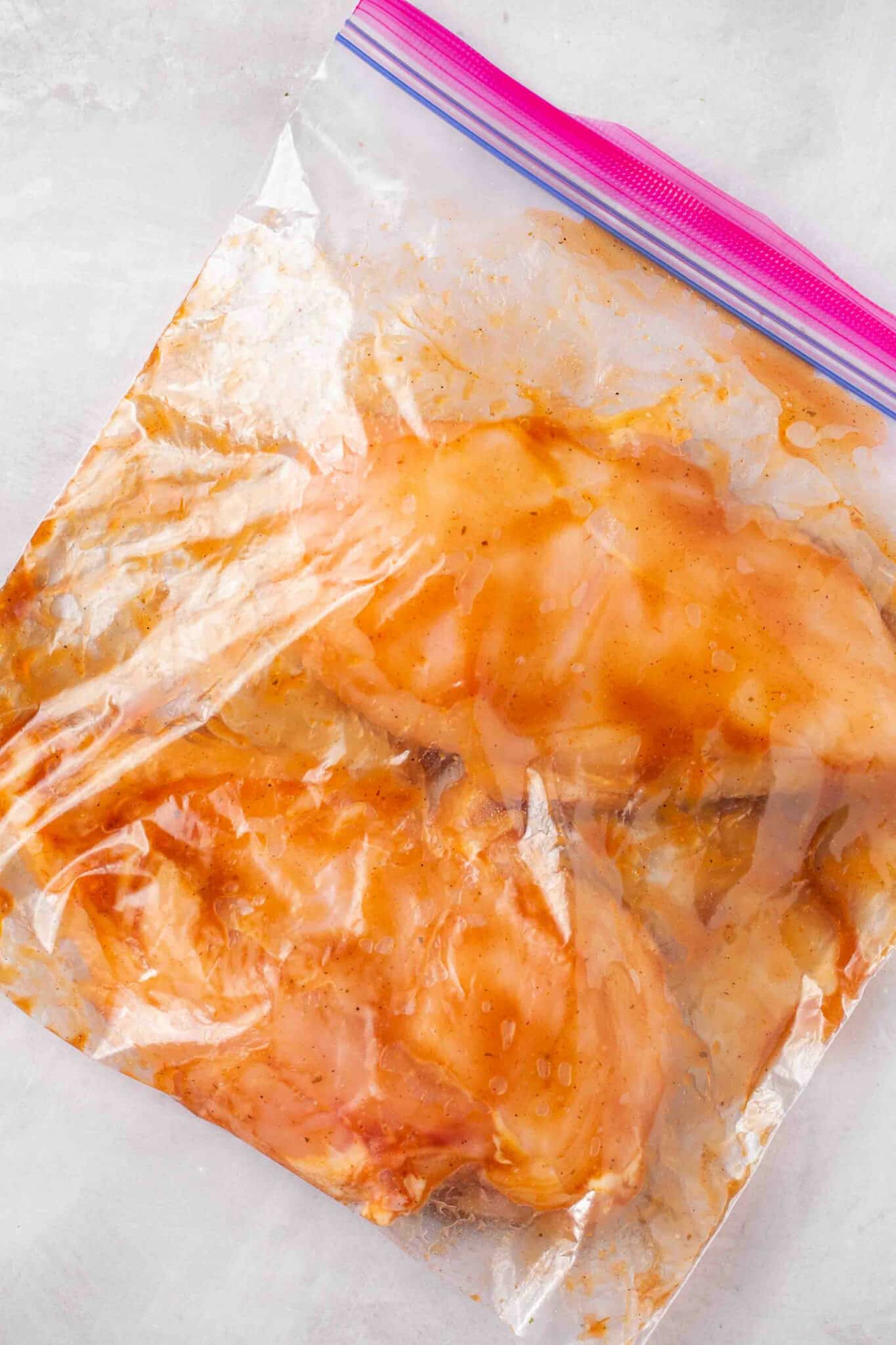 Marinating two chicken breasts in a bag.