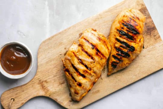 Grilled barbecue chicken on a cutting board.