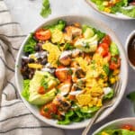 BBQ chicken salad served with crushed tortilla chips in a white bowl.