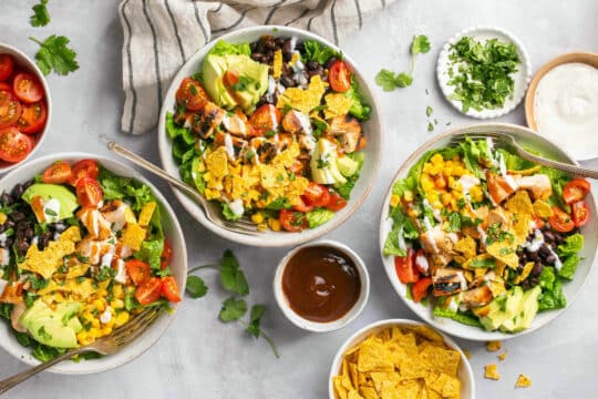 Salads made with barbecue chicken in white bowls.