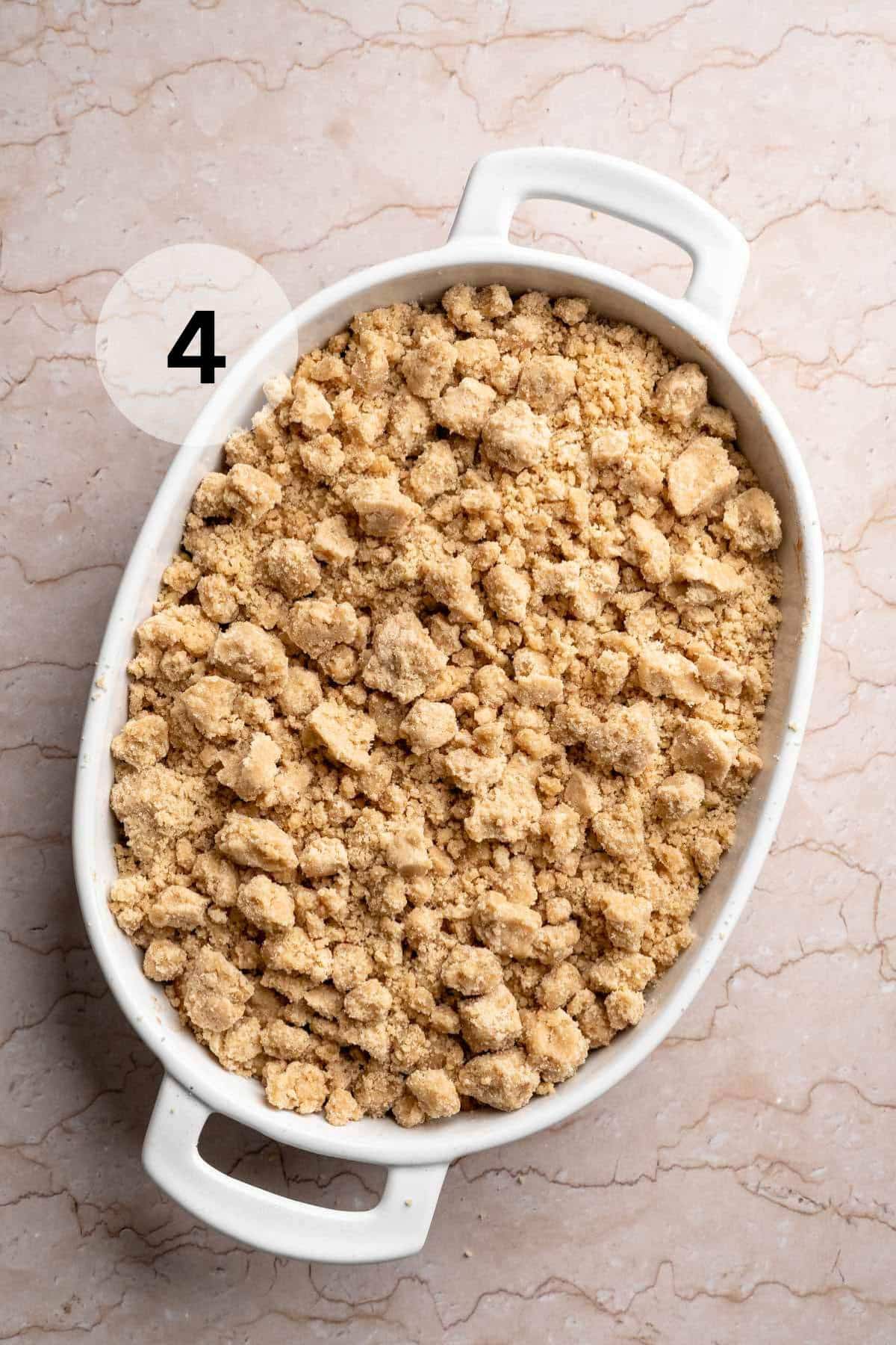 Unbaked apple crumble recipe in a white baking dish.