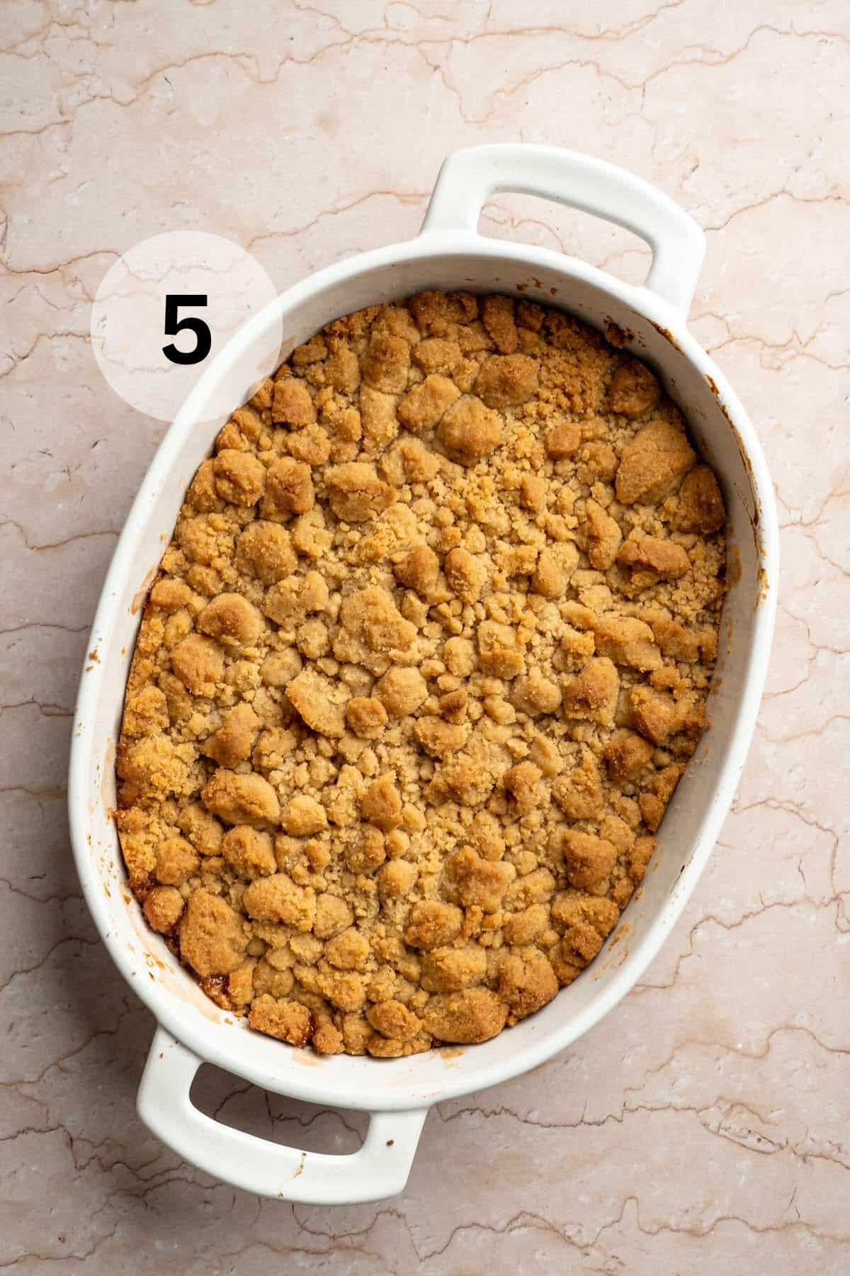 Baked apple crumble in a white dish.