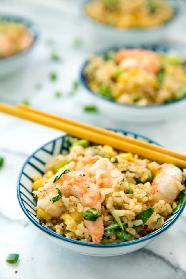 fried rice served in a small bowl with chopsticks