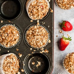 strawberry muffins with oat topping in a muffin pan