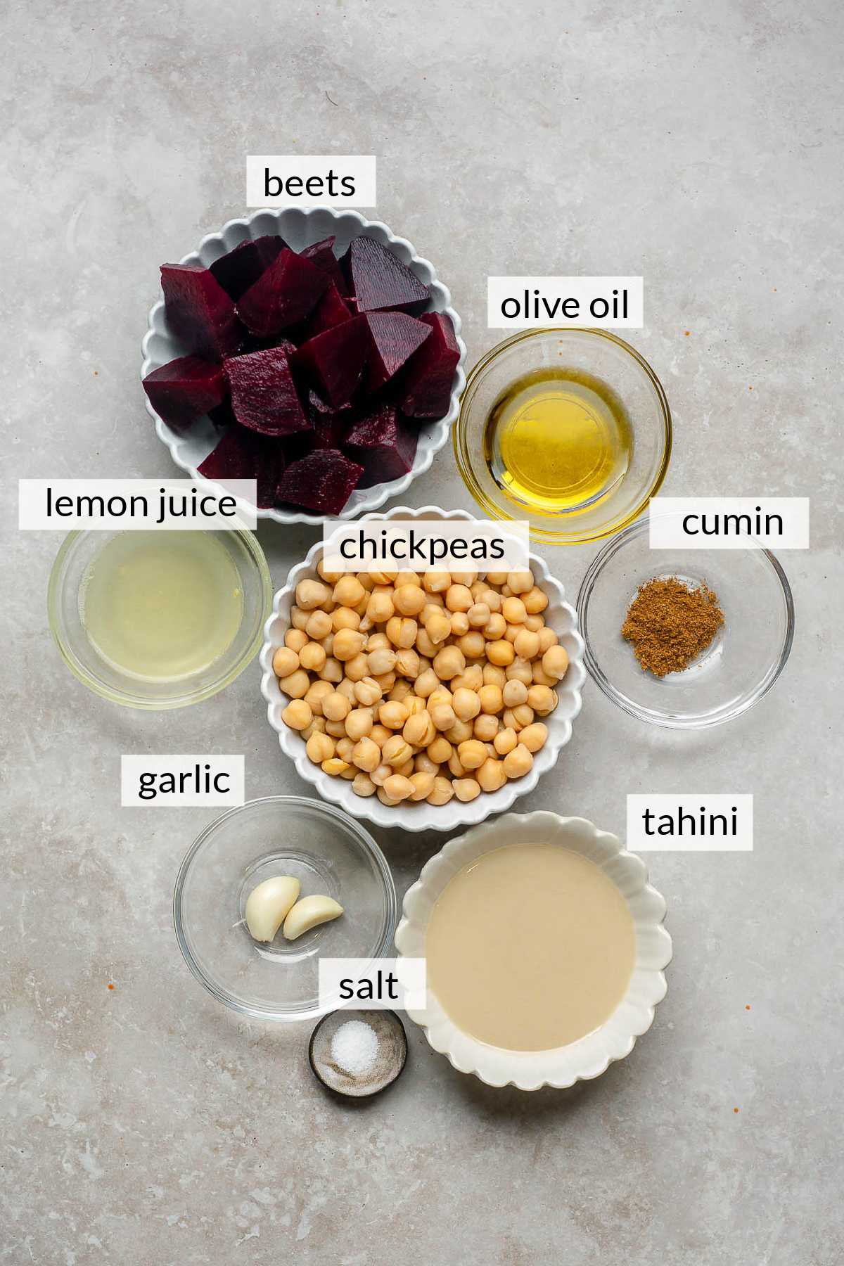 Chopped beets, olive oil, lemon juice, tahini, garlic and cumin in small bowls.