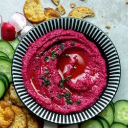 Beet hummus served with crackers and veggies.