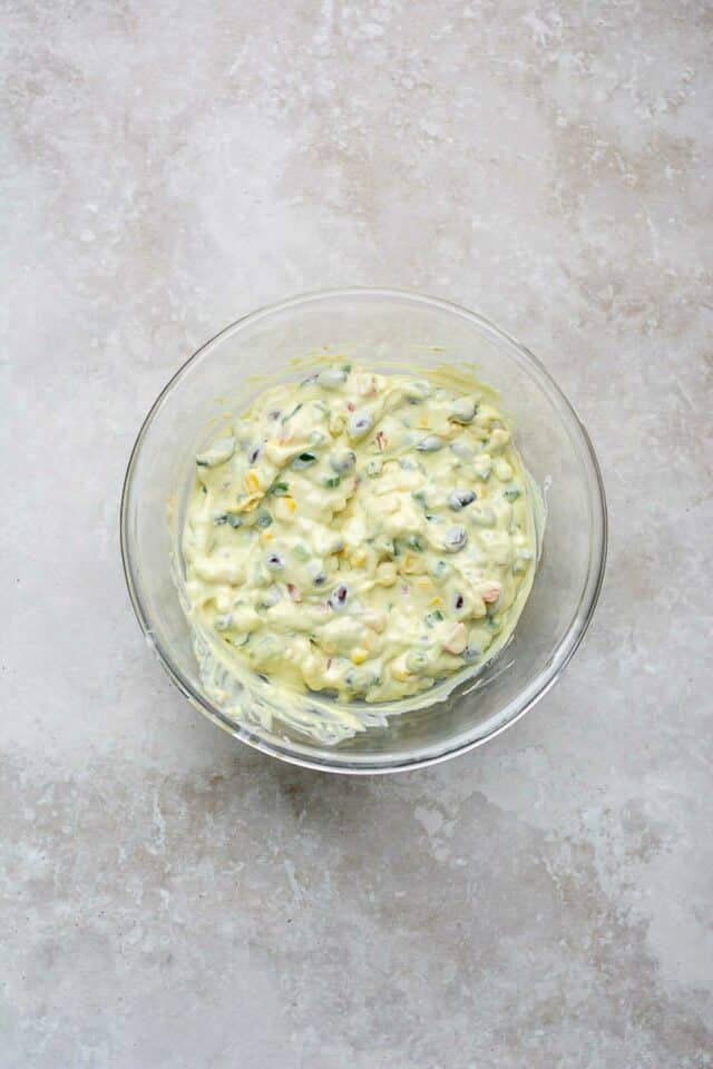 Cottage cheese dip made with black beans, tomatoes and corn in a large glass bowl.