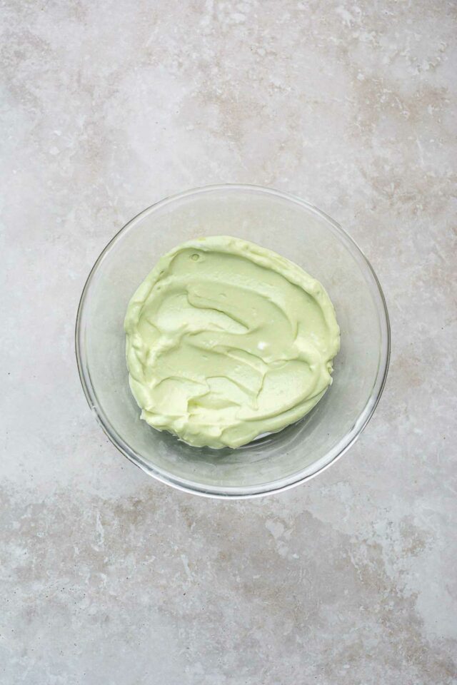 A creamy mix of blended cottage cheese and avocado in a glass bowl.
