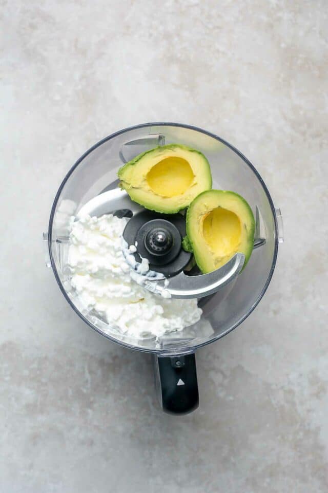 Cottage cheese in a food processor with an avocado.