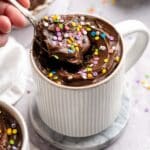 Getting a spoonful of frosted chocolate protein mug cake.