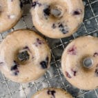 baked blueberry donuts topped with glaze on a wire cooling rack