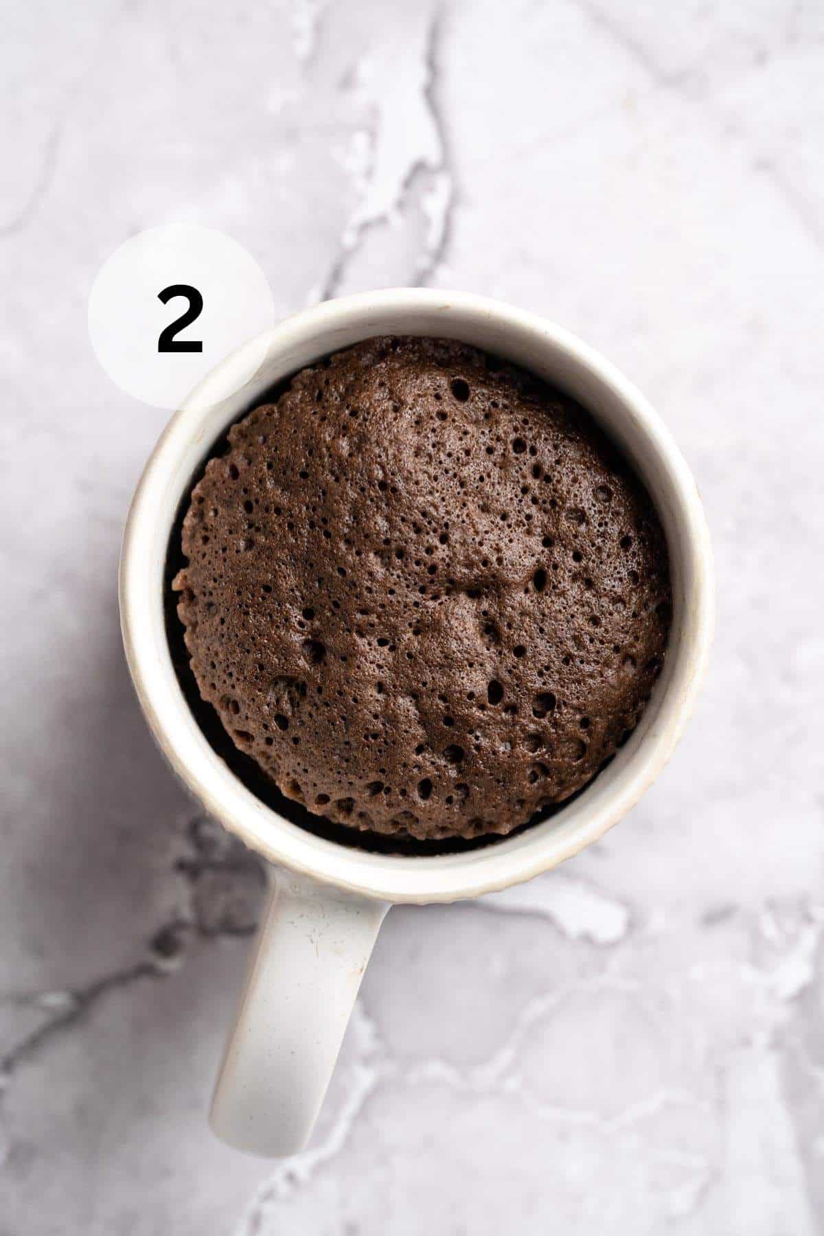 Chocolate protein mug cake in a white mug.