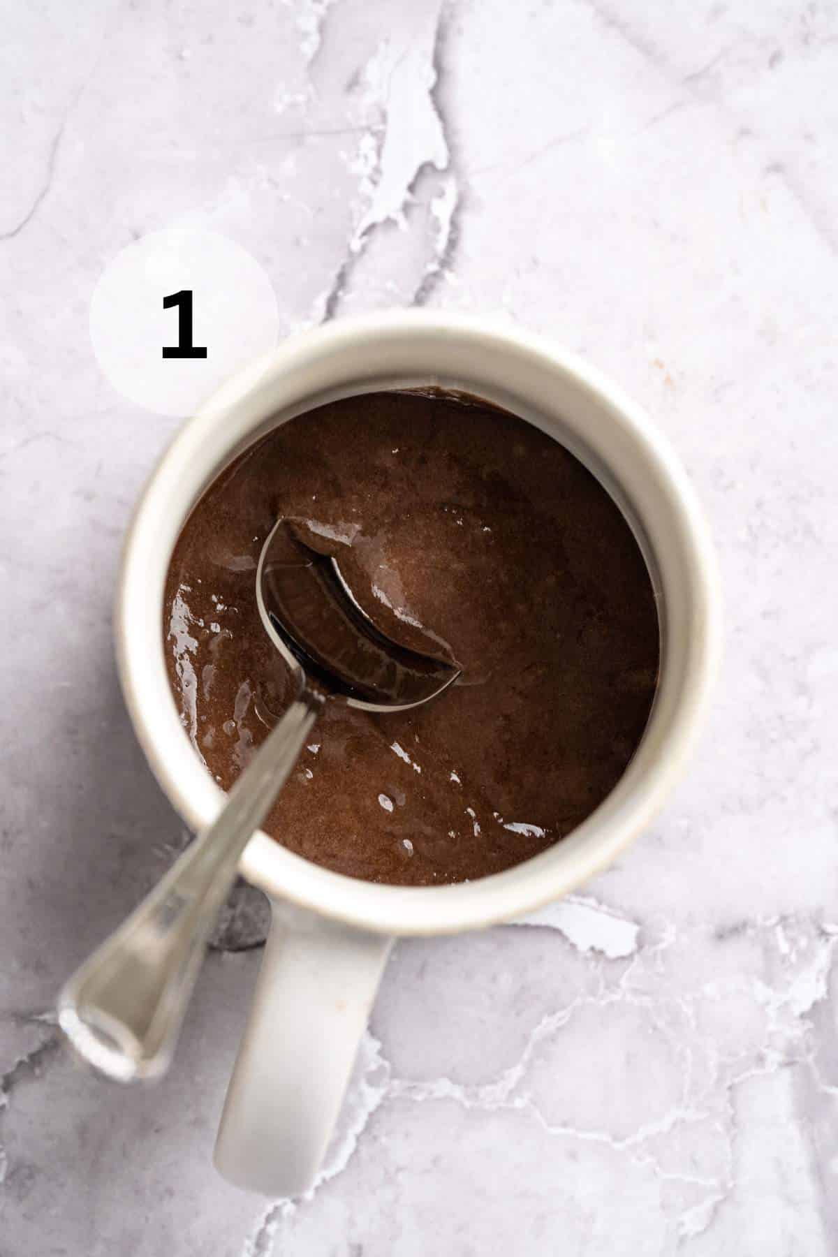 Using a spoon to stir cake mix, chocolate protein powder, water, and oil.