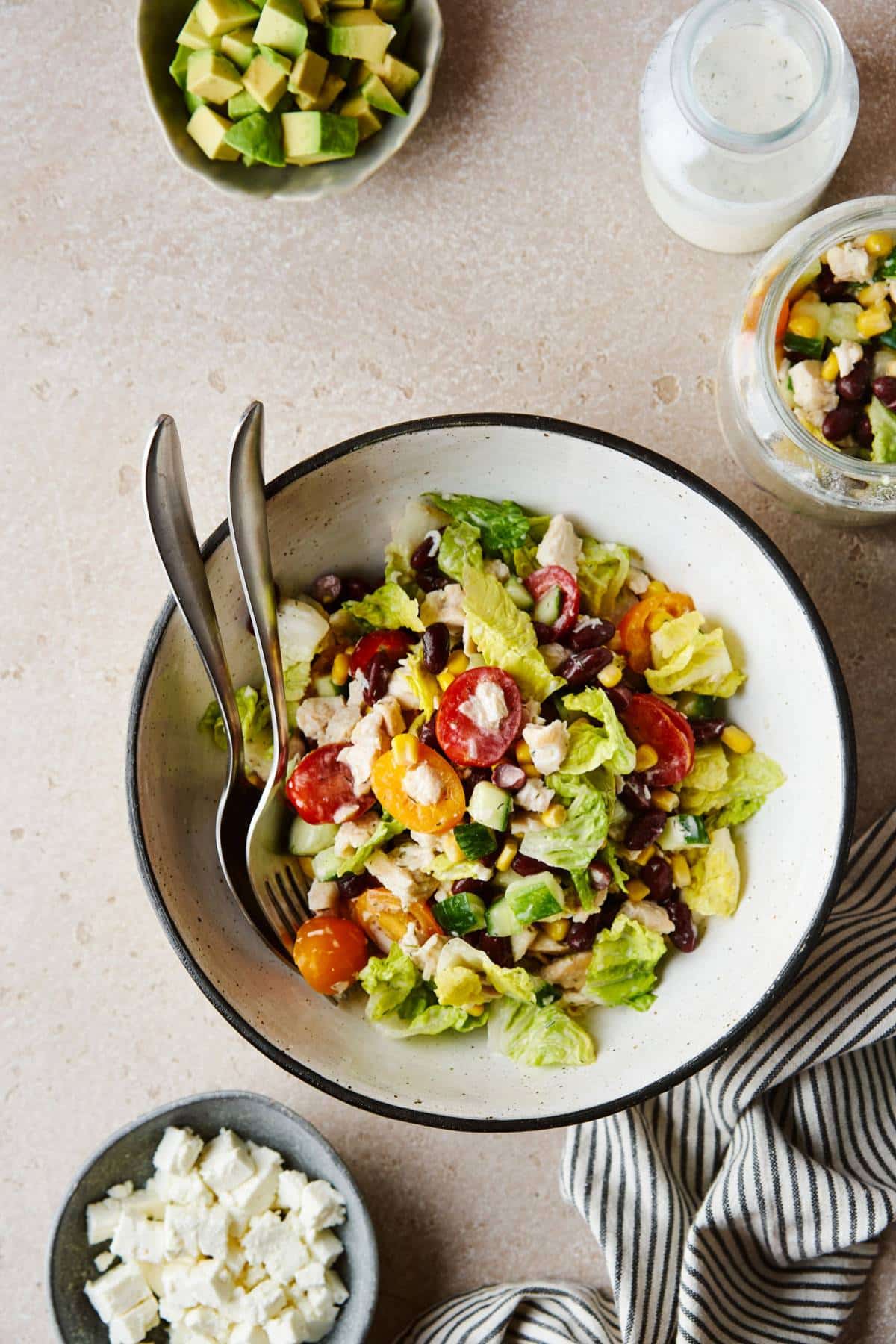 Salad in a bowl with lettuce tomatoes and crumbled cheese.