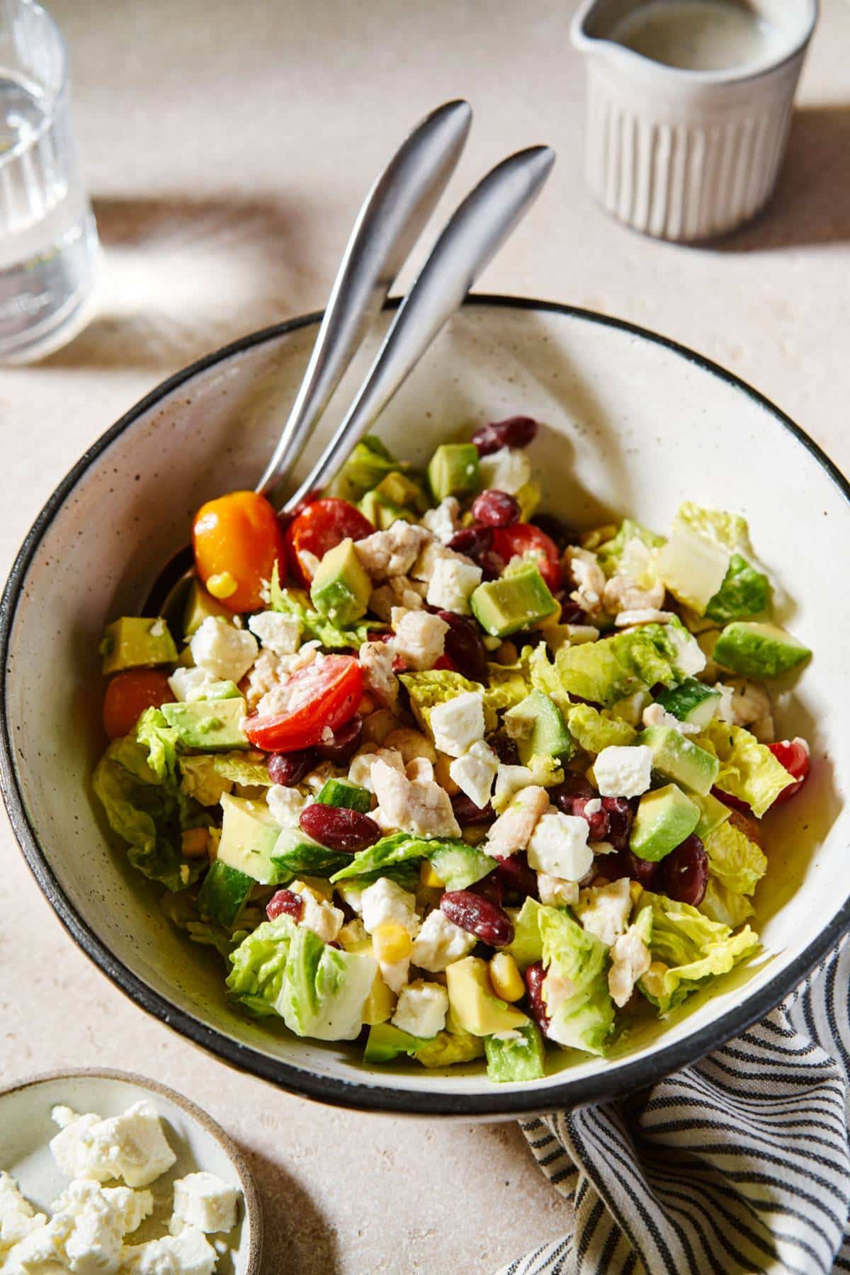 Jar salad poured into a white bowl and served with a fork.