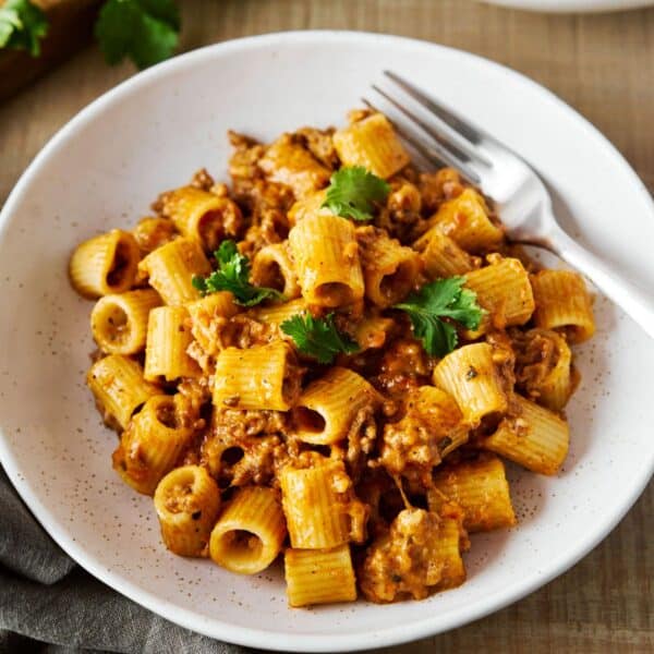 Mexican pasta served in a white bowl with a fork.