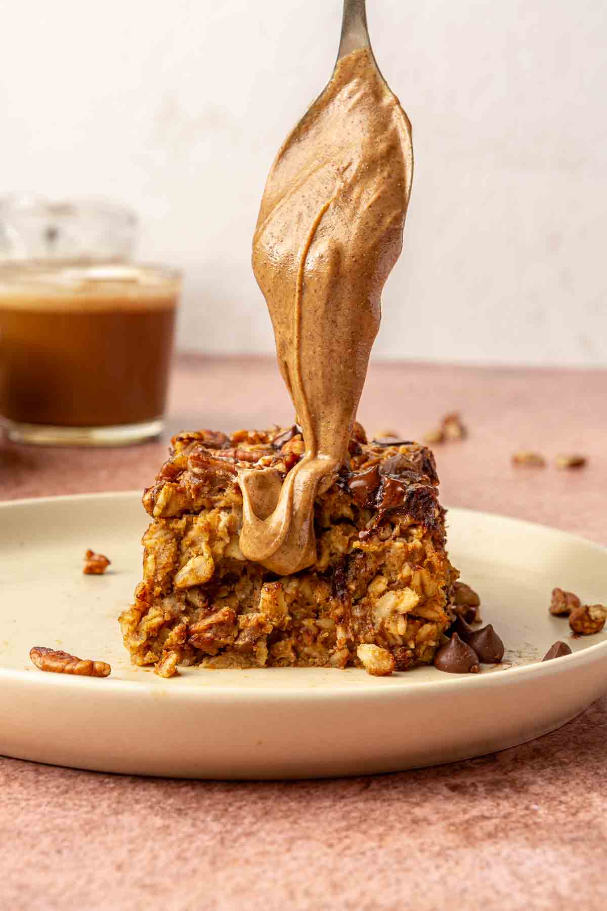 Drizzling almond butter over a serving of baked oatmeal.