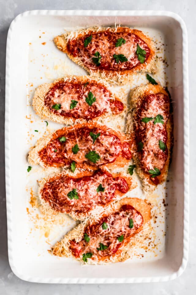 baking chicken parmesan on a baking sheet covered with parchment paper