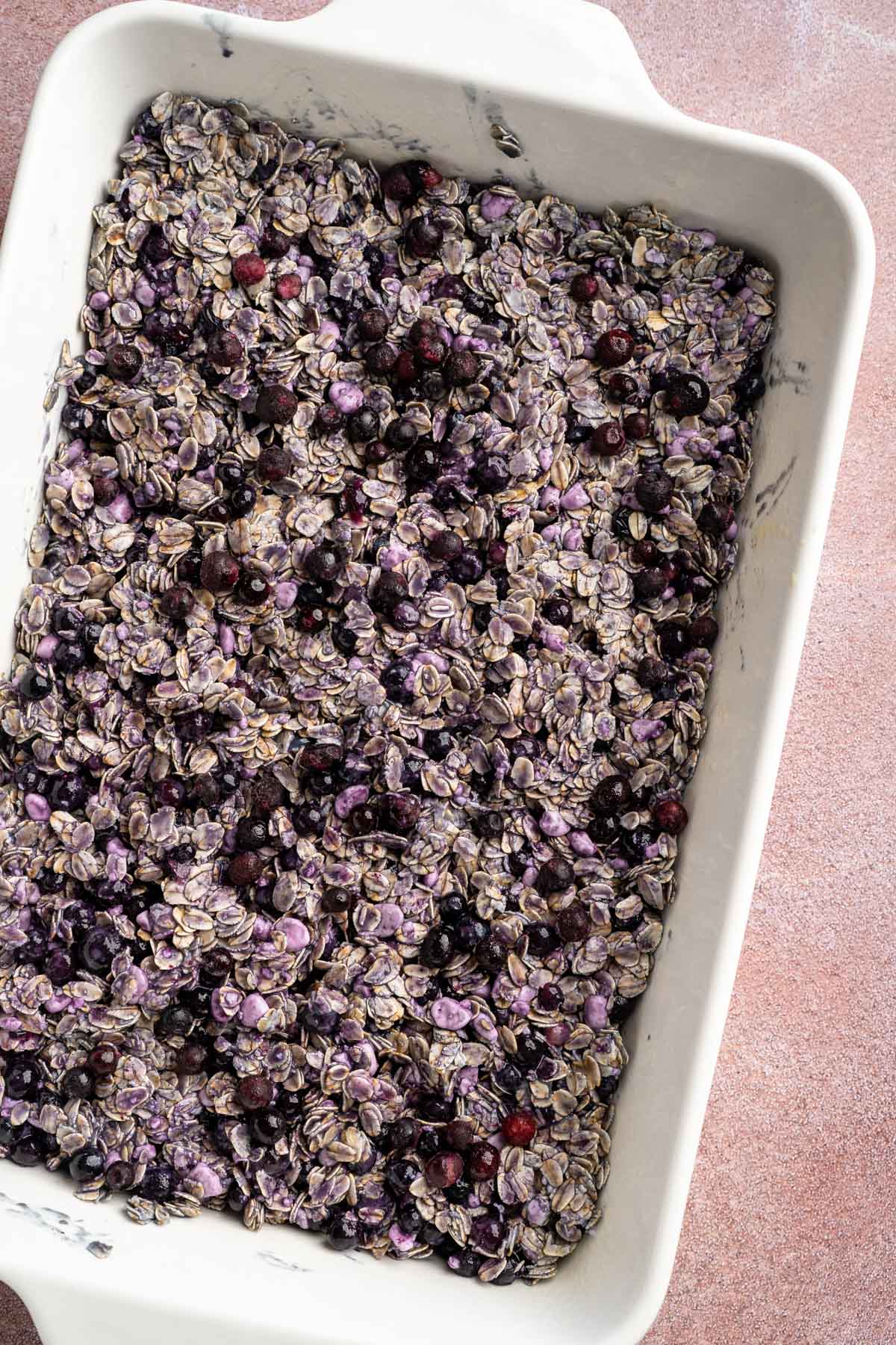 Blueberry oatmeal mixture spread into a casserole dish.