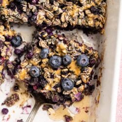Blueberry baked oatmeal being served out of a baking dish.