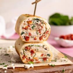 A Starbucks spinach feta wrap cut in half and stacked with a toothpick through the top.