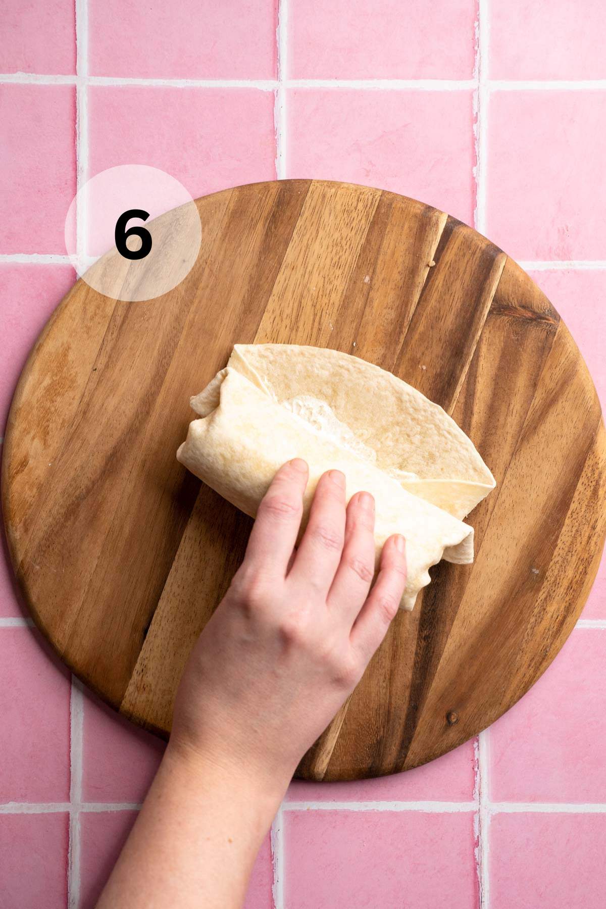 Folding a tortilla around egg white mixture.