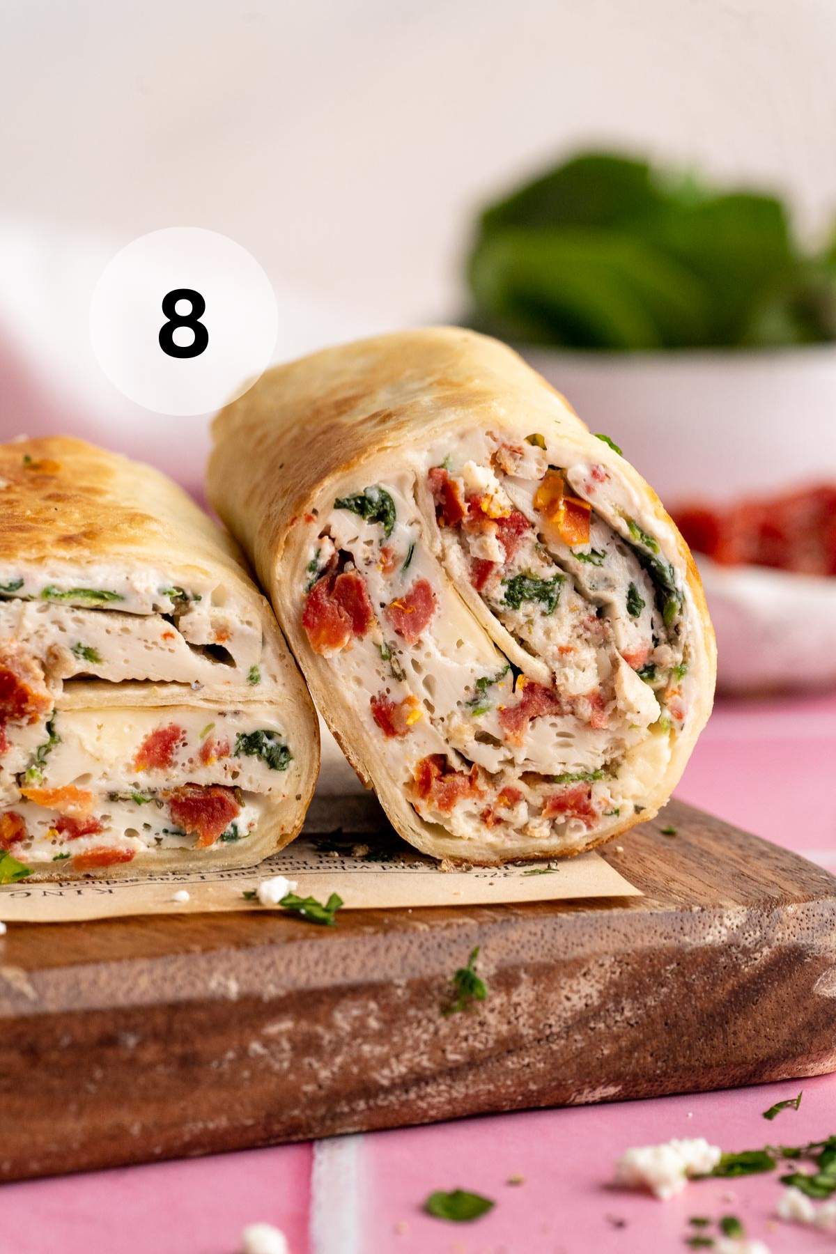 Starbucks spinach feta wrap on a parchment lined cutting board.