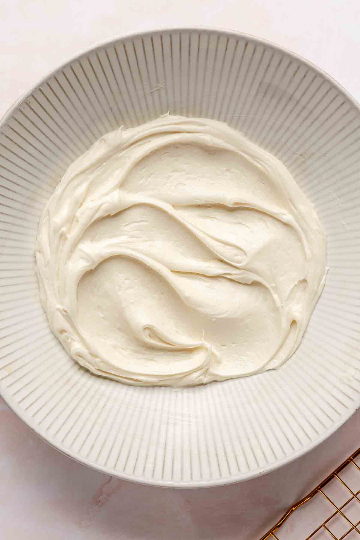 Smooth cream cheese frosting in a bowl.