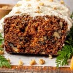 Iced carrot cake loaf topped with chopped walnuts.